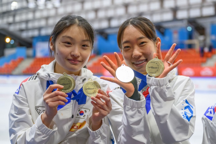 Two women holding medals in their handsDescription automatically generated