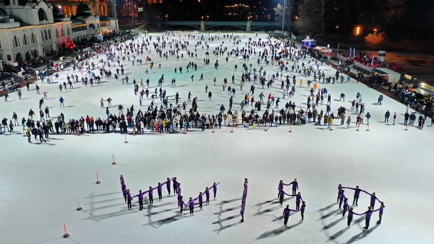 A large group of people on a ice rinkDescription automatically generated